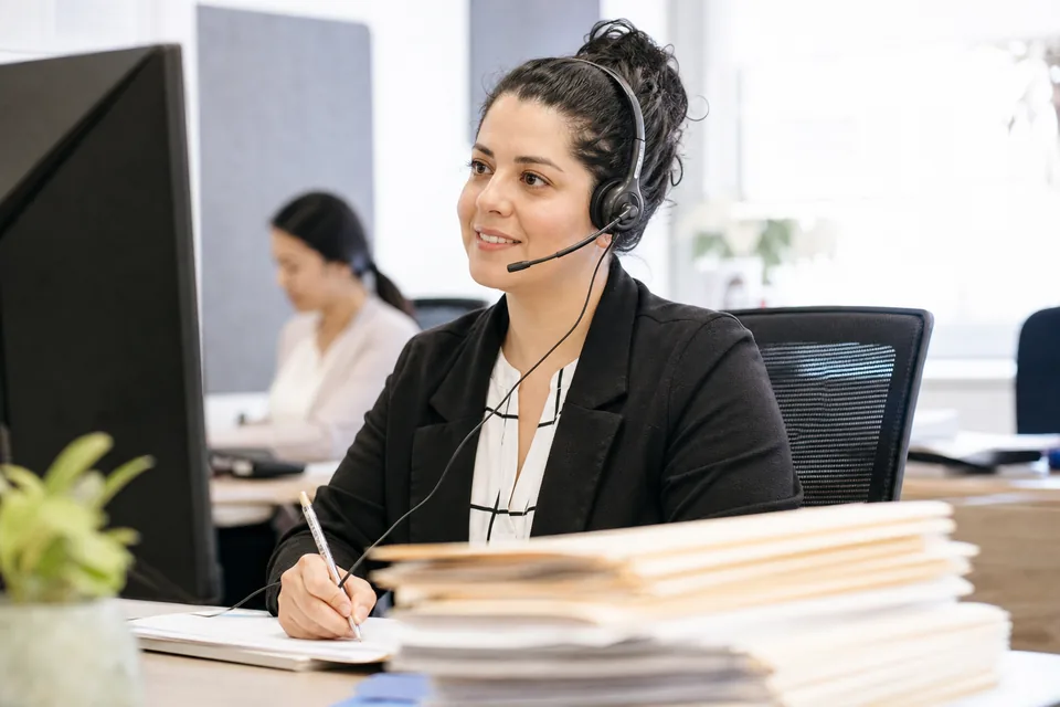 Bilingual intake coordinator at an immigration law firm taking a call from a prospective client